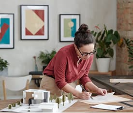 Professional reviewing architectural plans at a desk