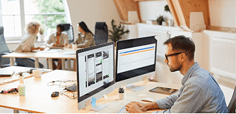 Designer working at dual monitors in an office